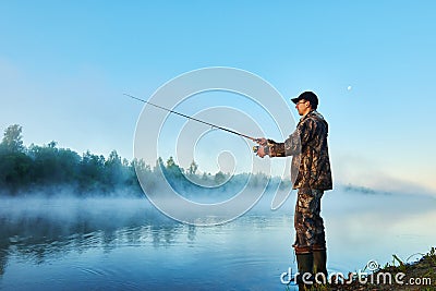 Fisher fishing on foggy sunrise Stock Photo
