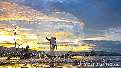 Fisherman of Bangpra Lake in action when fishing in the sunshine morning Stock Photo