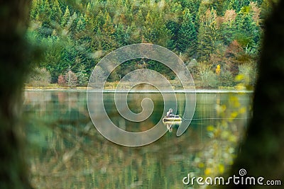 Fisherman in boat in automn day. fishing on lake inside the forest Stock Photo