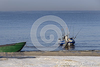 Fisherman with a boat and fishing rods on the shore of the Baltic Sea on a sunny day in the city of Klaipeda, Lithuania Editorial Stock Photo