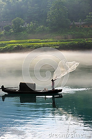 Fisherman casting net on river Stock Photo