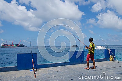 Fisherman catching fish using three rods Editorial Stock Photo