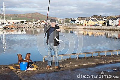 Fisherman catching a mackerel in Dingle harbour Editorial Stock Photo