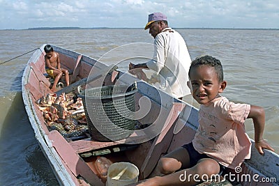 Fisherman, children and fish, Galibi, Surinam Editorial Stock Photo