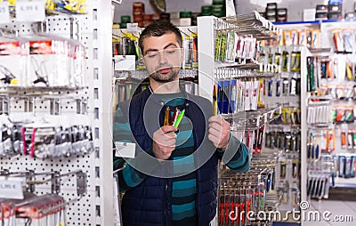 fisherman is considering fishing lures Stock Photo