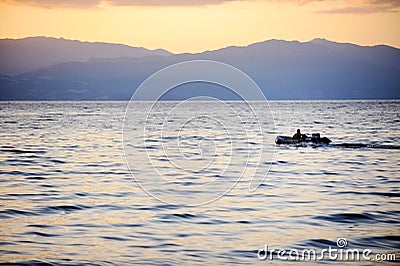 Fisherman driving a boat on Ohrid Lake at sunset Editorial Stock Photo