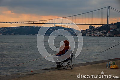 fisherman fishes on Bosphorus Istanbul on a Foggy sunrise Editorial Stock Photo