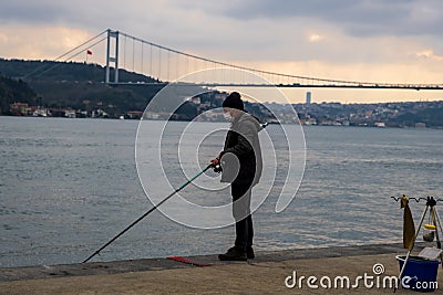 fisherman fishes on Bosphorus Istanbul on a Foggy sunrise Editorial Stock Photo