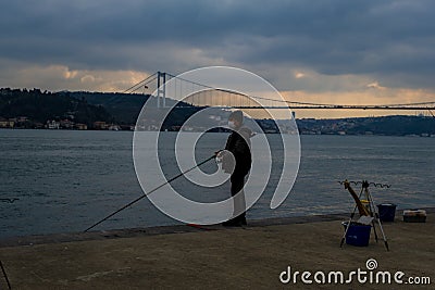 fisherman fishes on Bosphorus Istanbul on a Foggy sunrise Editorial Stock Photo