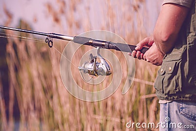 Fisherman fishing- Fisherman holding fishing rod Stock Photo