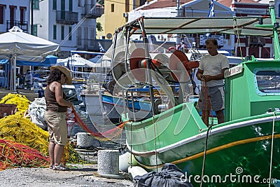 A fisherman and friend check fishing nets for holes in the harbour of the Greek island of Kastellorizo. Editorial Stock Photo