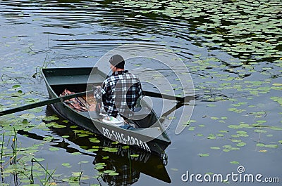 A fisherman in his boat at lake in Poland Editorial Stock Photo