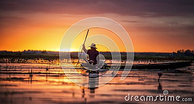 Fisherman in his traditional boat at sunrise Stock Photo