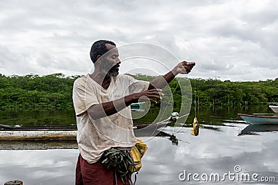 Fisherman holding fishing line with fish on hook Editorial Stock Photo