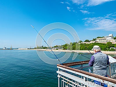 Fisherman on the bridge with a pier and jumping and walking people in Burgas, Bulgaria Editorial Stock Photo