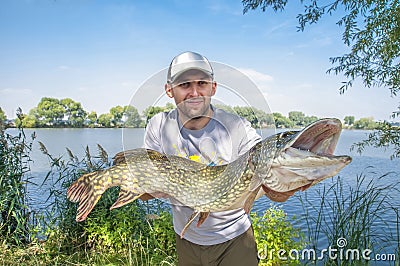 Fisherman with pike Stock Photo