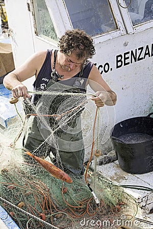 Fisherman removing fish nets in the port of estepona Editorial Stock Photo