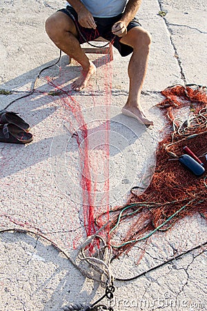 Fisherman reparing fishing net Stock Photo