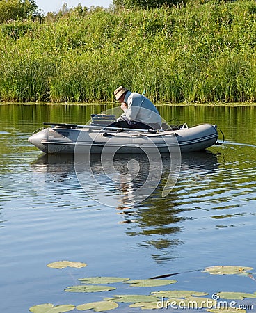 A fisherman in a rubber boat Stock Photo