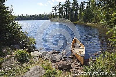 A fisherman's canoe on rocky shore in northern Minnesota lake Stock Photo