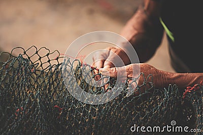 fisherman`s hand, repairing fishing net Stock Photo