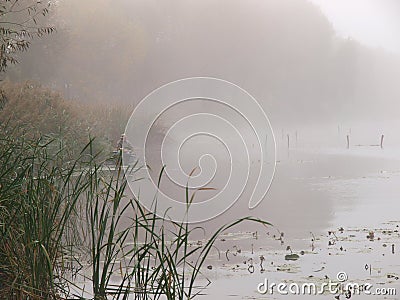 Fisherman silhouette on a boat on a misty morning lake Editorial Stock Photo