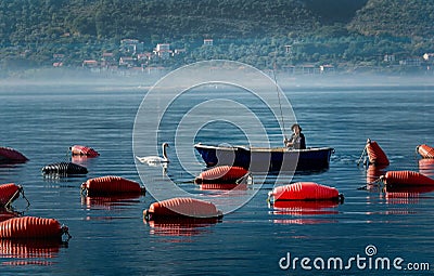 Fisherman in the small boat by Marine water ponds for fish far Editorial Stock Photo