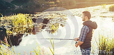 Fisherman with a spinning and bait catching fish on a lake or river. Man on a weekend with a fishing road. Hobby and Stock Photo