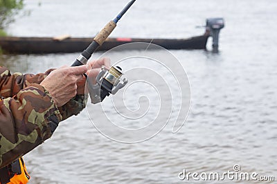A fisherman with a spinning rod catches fish on the river Stock Photo