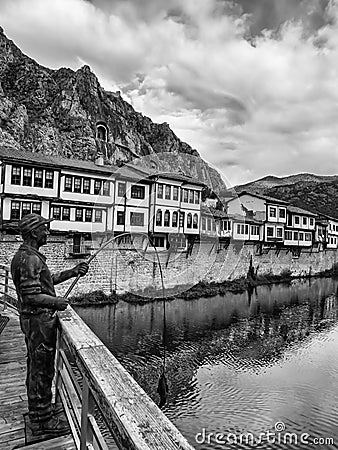 Fisherman statue and historic riverside houses in Amasya city, Turkey. Ottoman house Editorial Stock Photo