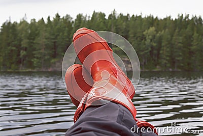 Fisherman taking a break with rubber boots resting on bulwark. Stock Photo