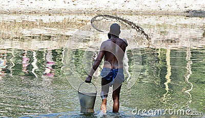 Fisherman throwing feeds in a pond in India Editorial Stock Photo