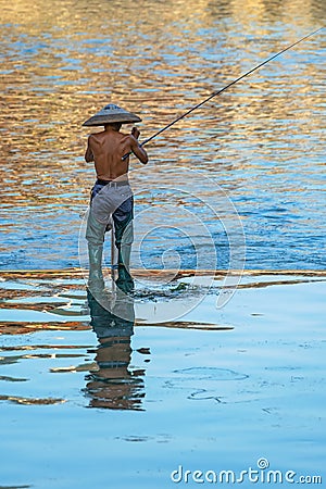 Man catching fish in Fenghuang Editorial Stock Photo