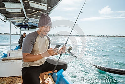 fisherman using a smartphone to send messages while fishing Stock Photo