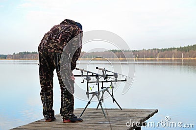 Fisherman watches feeders on rod pod with electronic bite alarms Stock Photo