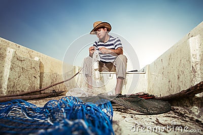 Fisherman at work, cleaning the nets Stock Photo