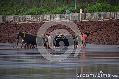 Fishermen carring out their boat Editorial Stock Photo