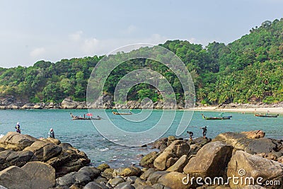 Fishermen catching fish on the rocky tropical beach in Thailand. Sunny day Editorial Stock Photo