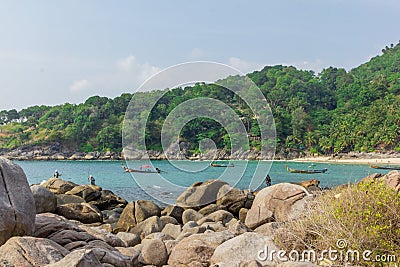 Fishermen catching fish on the rocky tropical beach in Thailand. Sunny day. Summer Editorial Stock Photo