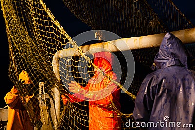 Fishermen choose a trawl with fish the ship Stock Photo