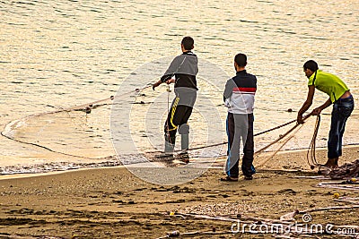 Fishermen on coast catching fish in nets in sunrise, MDiq, Morocco Editorial Stock Photo