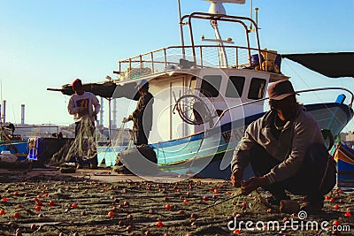 Fishermen collecting and cleaning fishing nets after a fresh catch Editorial Stock Photo