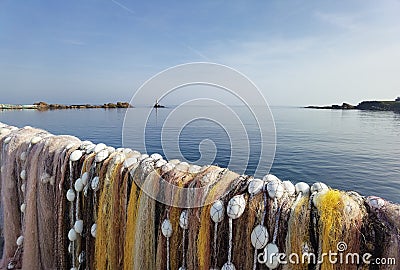 Fishermen colorful nets in front of calm sea water and clear sky. Seaside landscape, wallpaper Stock Photo