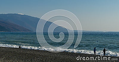 Fishermen are fishing in Black Sea. View of Caucasian mountains in Abkhazia from Russian side. December winter sea Editorial Stock Photo