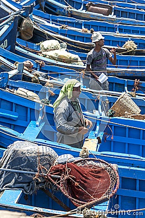 Fishermen stand amongst a sea of boats in the harbour in Essaouira in Morocco. Editorial Stock Photo