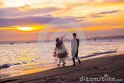 Fishermen at sunset in Vietnam. Men go on the beach with nets in hand. The silhouettes of the fishermen. Editorial Stock Photo