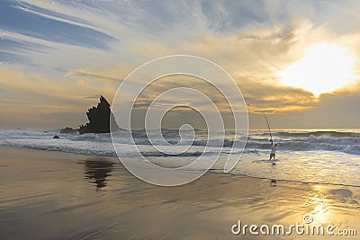 Fisherman in adraga beach at sunset Stock Photo
