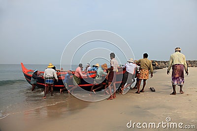 Fishermen work hard to bring the fishing boat to the shore Editorial Stock Photo