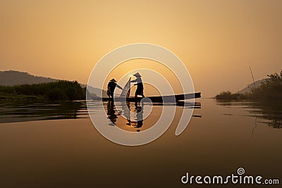 Fishermen are working on the fishing boat in Mekong River during in the morning Editorial Stock Photo