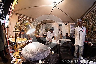 Fisheye shot of restaurant kitchen kiosk with chefs making roti nan bread with ulta tawa and gravy being prepared Editorial Stock Photo
